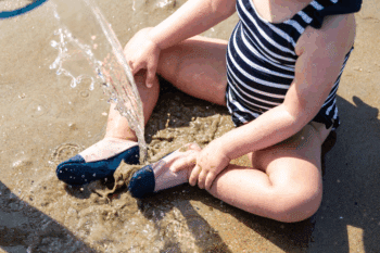 Les Petites Crevettes aux pieds d'un bébé dans le sable