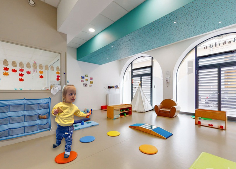 Photo montrant un enfant dans une salle de motricité en chaussons souple Les Pas Petits.