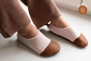 Les Petits Velours Pyjama Rose pâle aux pieds d'un enfant