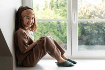 Les Petits Velours Pyjama Gris vert aux pieds d'une petite fille