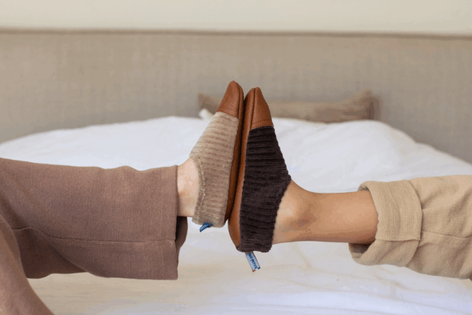 Les chaussons souples Les Petits Velours Noisettes aux pieds d'un enfant