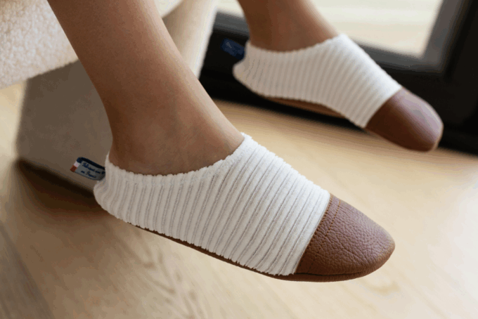 Les chaussons souples Les Petits Velours Ivoire aux pieds d'un enfant