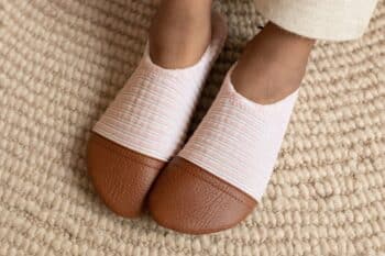 Les Petits Velours Rose pâle aux pieds d'un enfant