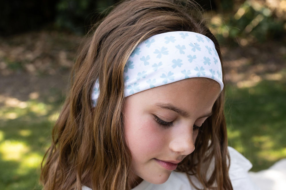 Bandeau au motif trèfles dans les cheveux d'une petite fille
