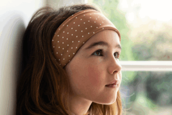Bandeaux à pois dans les cheveux d'une petite brune