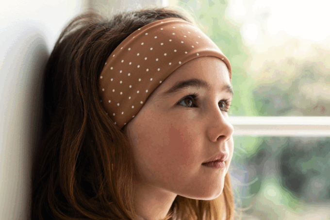 Bandeaux à pois dans les cheveux d'une petite brune