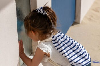 chouchou marin sur une petite fille à la plage et sac à dos marins