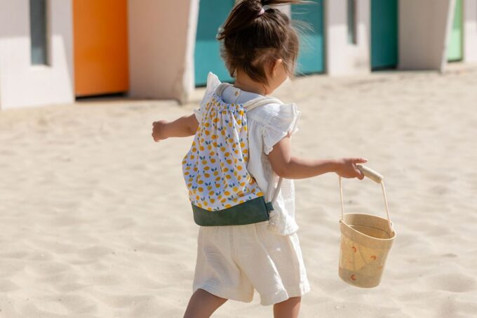 sac Citrons Jaunes sur une petite fille sur le sable