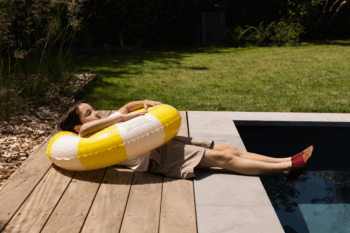 Chaussons souples couleur cherry aux pieds d'un petit garçon au bord d'une piscine