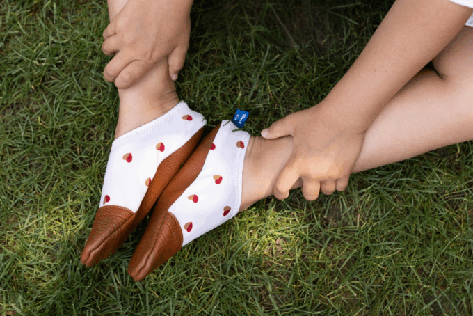 Chaussons souples blancs au motif petits cœurs bicolores dans l'herbe