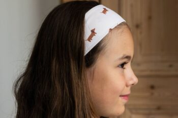 Petite fille portant un bandeau à motif teckels