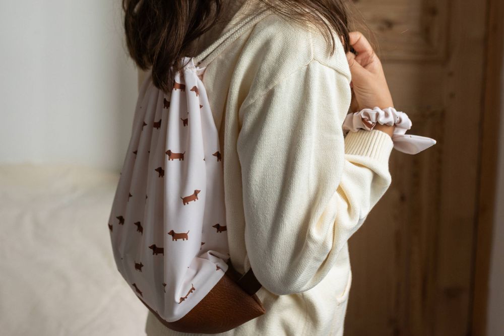 Petite fille portant un sac à motif teckel