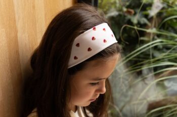 Petite fille portant un bandeau à motif coeur