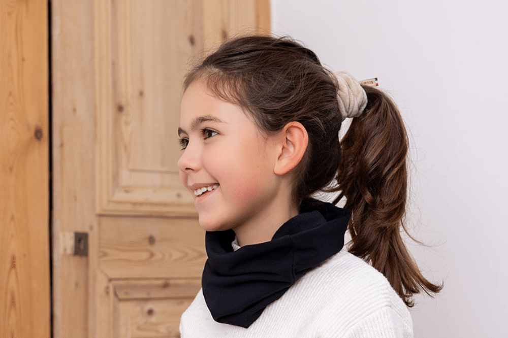 Les Petits Tours de cou Polaires Réglisses au cou d'une petite fille