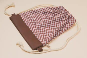 Les Petits Sacs Damiers à plat sur fond blanc