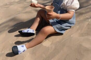 Les Petites Tortues aux pieds d'une petite fille dans le sable