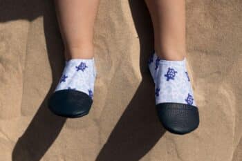 Les Petites Tortues aux pieds d'un enfant dans le sable