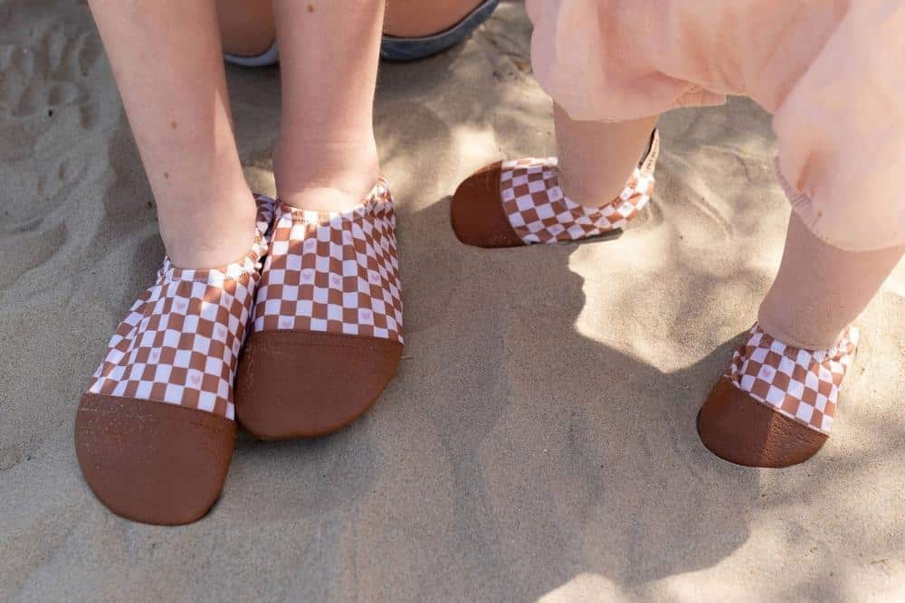 Les Petits Damiers aux pieds d'un bébé et de sa maman