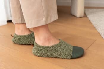Les Petites Bouclettes Gris vert aux pieds d'une femme