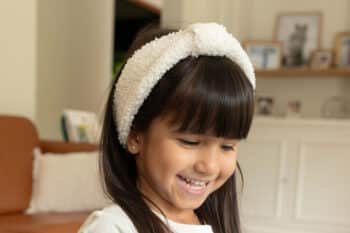 Les Petits Bandeaux Bouclettes Ivoire dans les cheveux d'une petite fille