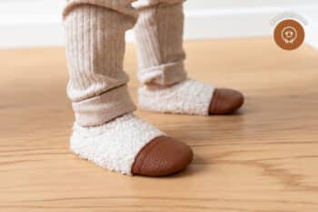 Les Petites Bouclettes Ivoire aux pieds d'un enfant
