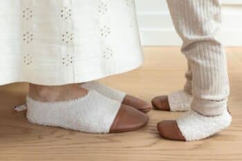 Les Petites Bouclettes Ivoire aux pieds d'un enfant et de sa maman