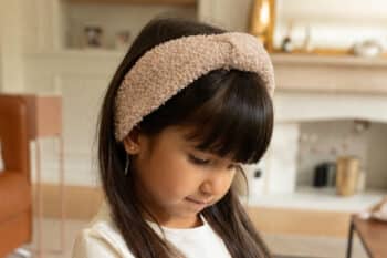 Les Petits Bandeaux Bouclettes Noisettes dans les cheveux d'une petite fille