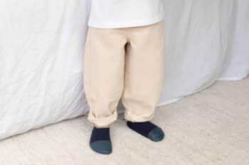 Les Petits Tricots Bleu profond aux pieds d'un enfant