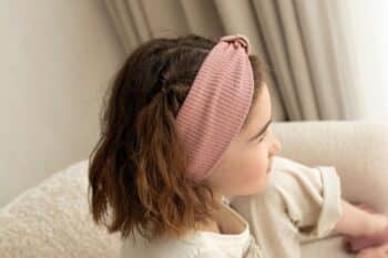 Les Petits Bandeaux Tricots Vieux rose dans les cheveux d'une petite fille