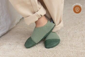 Les Petits Tricots Vert amande aux pieds d'un enfant