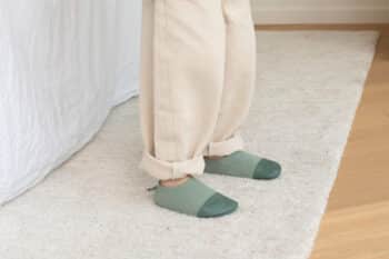 Les Petits Tricots Vert amande aux pieds d'un enfant