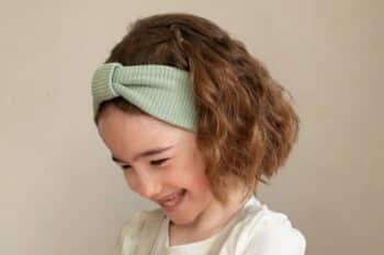 Les Petits Bandeaux Tricots Vert amande dans les cheveux d'une petite fille