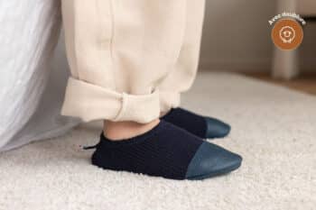 Les Petits Tricots Bleu profond aux pieds d'un enfant