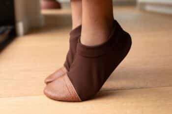 Les Petits Polaires Marron chocolat aux pieds d'un enfant